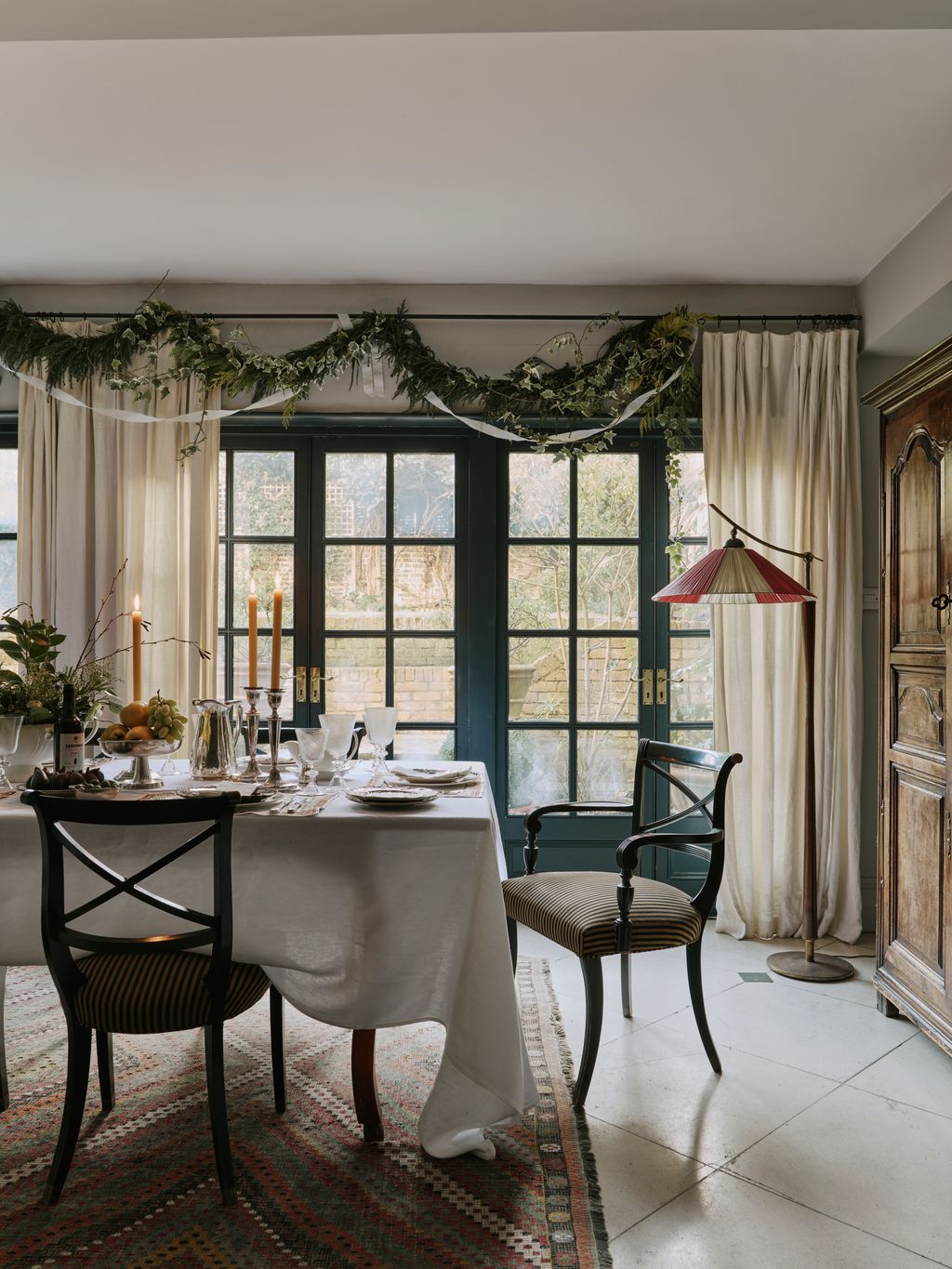 Image may contain Chair Furniture Home Decor Rug Window Table Door French Window Candle Lamp and Dining Table